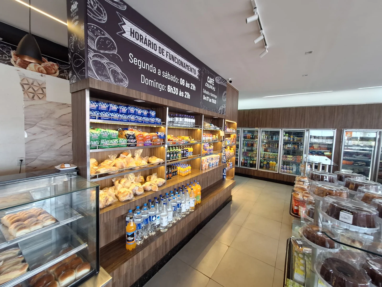 Interior da ManáPan com prateleiras de pães, biscoitos e bebidas e geladeiras ao fundo