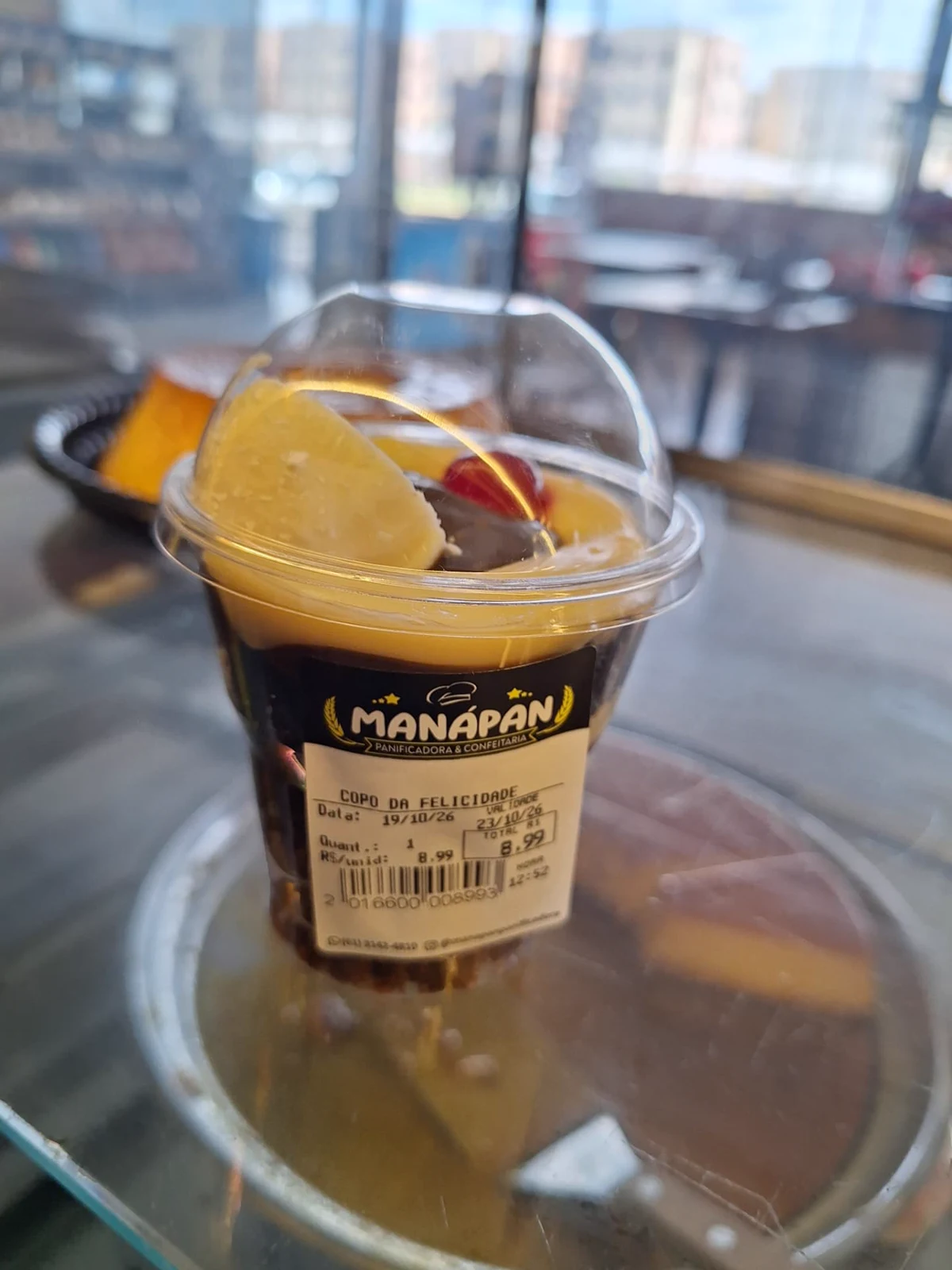 Copo da felicidade da ManáPan com camadas de chocolate, creme e morango em copo transparente com tampa
